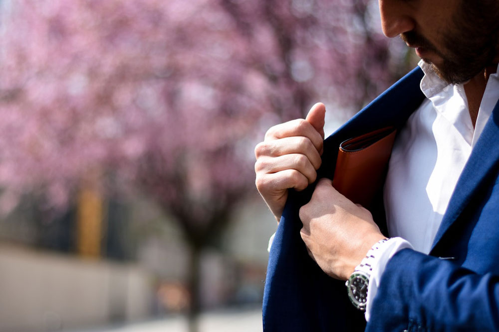 Muž si vyťahuje peňaženku zo obleku
